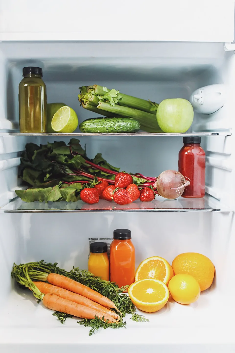A person organizing fresh food in a refrigerator
